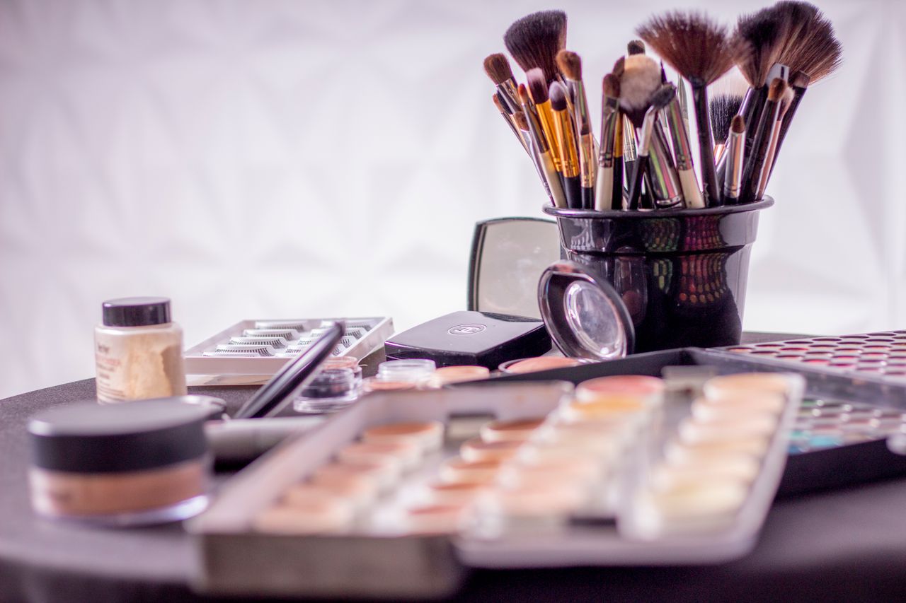 Services Close-up of a professional makeup brush set and cosmetics on a table for beauty use.