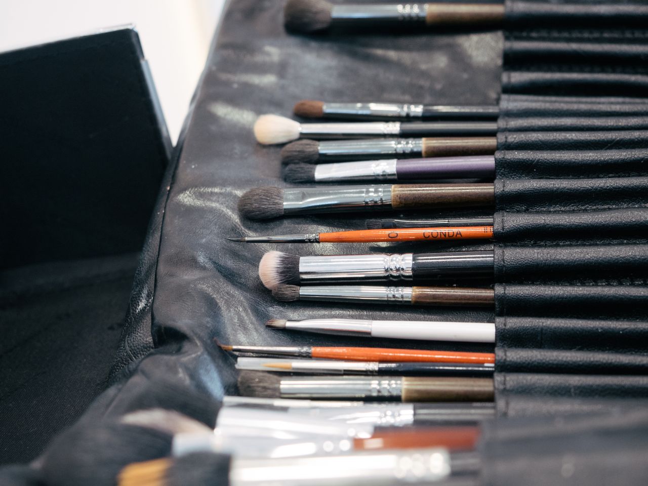 Services A collection of professional makeup brushes neatly arranged in a black case, perfect for cosmetic application.